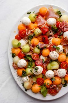 a white plate topped with lots of different types of food on top of a table