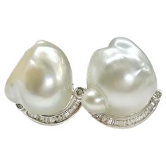 14 Karat White Gold South Sea Baroque Pearl Diamond Earrings. Each earring features a South Sea Baroque pearl and a semi-curve of channel-set baguettes and four bezel-set round diamonds. The four round diamonds measure 1.5mm each/0.015ct for a total carat weight of 0.16tcw. One pearl has a more blueish tone than the other, however they both have good luster. The earrings measure approximately 18mm high x 10.5mm wide and include a push back. The total gold weight of the earrings is 10.18 grams. Pearl Diamond Earrings, Pearl And Diamond Earrings, South Seas, Channel Set, Pearl Diamond, Stone Design, Gold Pearl, Baroque Pearls, Silver Heart