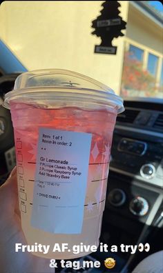 a person holding up a plastic cup with pink liquid in it that says fruity af give it a try & tag me