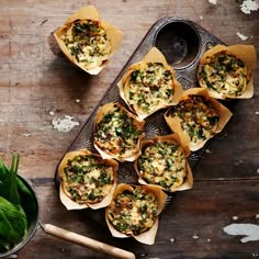 small cups filled with food sitting on top of a wooden table next to green vegetables