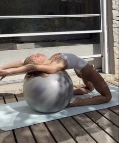 a woman is doing yoga on an exercise ball