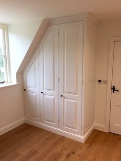 an empty room with white closets and wooden floors