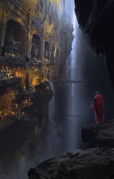 a man standing in the middle of a cave looking at candles on the floor and walls