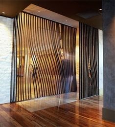 an open door in the middle of a room with wood flooring and glass walls