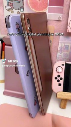 two nintendo wii game controllers sitting next to each other on top of a table in front of a pink wall