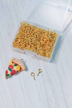 a plastic container filled with yellow sprinkles next to two small pieces of pizza