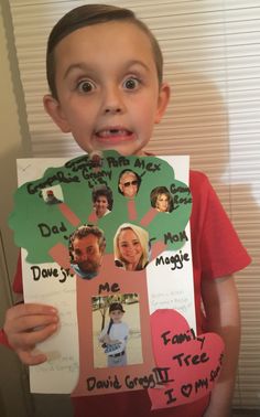 a young boy holding up a family tree cutout with pictures of his parents and grandparents