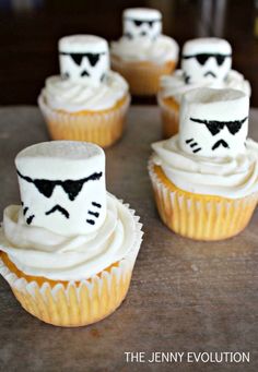 some cupcakes with white frosting and black faces on them