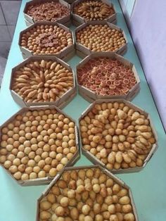 several trays filled with different types of nuts on a blue table top next to each other