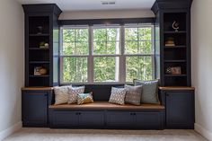 a window seat in the corner of a room with built - in bookshelves