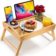 a wooden tray with breakfast food and an ipad on it