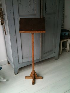 a small wooden table sitting on top of a hard wood floor next to a cabinet