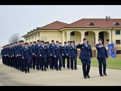 a group of uniformed men standing in front of a building