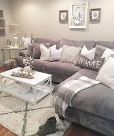 a living room filled with furniture and pillows on top of a white rug in front of a gray couch