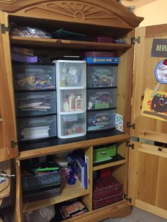 a wooden cabinet filled with lots of toys and storage containers on top of it's sides