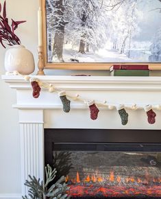 a fireplace with christmas stockings hanging from it's mantle next to a painting on the wall