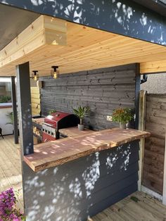 an outdoor bbq and grill area on a deck