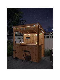 an outdoor bar with lights on it and two stools in front of the bar