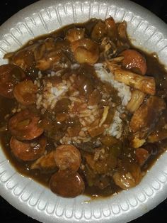 a white plate topped with meat and rice covered in gravy