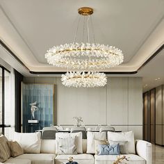 a living room filled with lots of furniture and a chandelier hanging from the ceiling