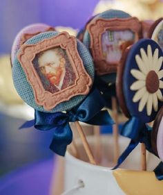 there are some lollipops with pictures on them in a cupcake holder