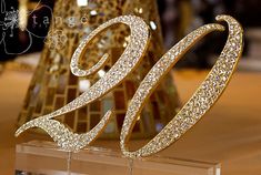 a golden cake topper sitting on top of a table next to a glass vase