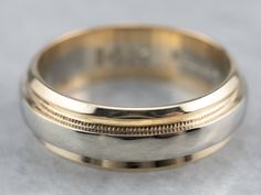 a close up of a wedding ring on a table with a gray surface in the background