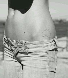 a black and white photo of a woman's stomach with a map tattoo on it