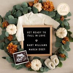 a wreath with baby's names and pumpkins on it, next to a sign that says get ready to fall in love