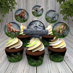 an assortment of cupcakes with dinosaur images on them