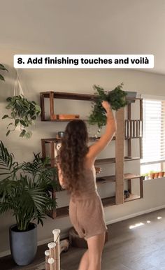 a woman is standing in front of a shelf with plants on it and the words 8 add finishing touches and volla