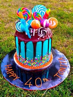 a birthday cake with candy and lollipops on it