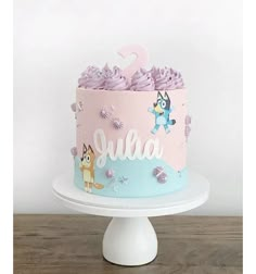 a pink and blue cake with an animal on top