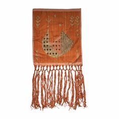 an orange wall hanging with fish and leaves on it's fringed edge, against a white background