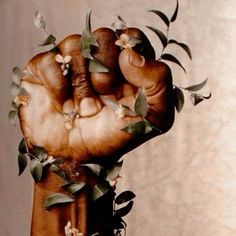 a hand with flowers on it holding something in the air