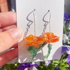 Elevate your style with our exquisite California Poppy Dangle Earrings, meticulously handcrafted using high-quality shrink plastic. These botanical-inspired earrings showcase the vibrant beauty of the iconic California poppy, capturing the essence of nature in a unique and wearable art form. The lightweight design ensures comfort, making them perfect for everyday wear or as a statement accessory for special occasions. Each pair is carefully crafted with love and attention to detail, making them a thoughtful and one-of-a-kind gift for nature enthusiasts. Embrace the charm of handcrafted jewelry and add a touch of floral elegance to your collection with these stunning California Poppy Dangle Earrings. 🌼✨ Summer Flower Earrings In Sterling Silver For Gift, Summer Flower Sterling Silver Earrings For Gift, Sterling Silver Flower Earrings For Summer, Sterling Silver Flower Earrings For Summer Gift, Orange Flower Earrings For Gift, Summer Flower Dangle Earrings Gift, Summer Dangle Flower Earrings Gift, Handmade Flower Dangle Jewelry For Summer, Handmade Flower Drop Earrings As Gift