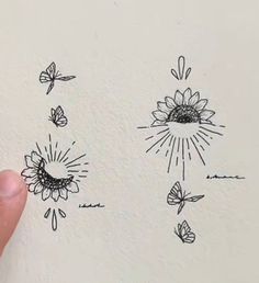 someone is drawing sunflowers and butterflies on the wall