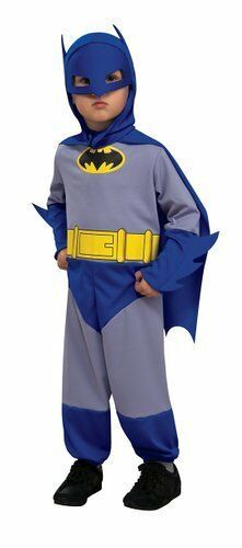 a little boy dressed as batman standing in front of a white background with his hands on his hips