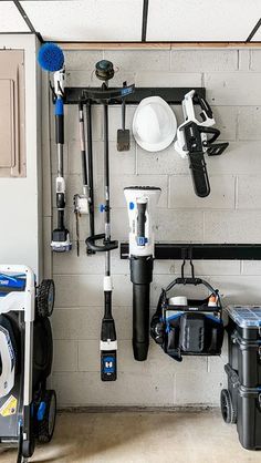 there are many different types of tools hanging on the wall in this garage, including cleaning equipment