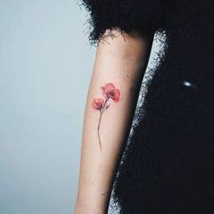 a woman with a red flower tattoo on her arm