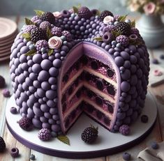 a cake with purple frosting and lots of berries on the top is cut in half