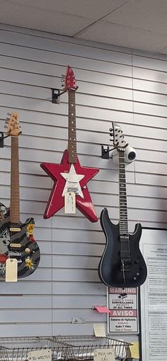 several guitars are hanging on the wall