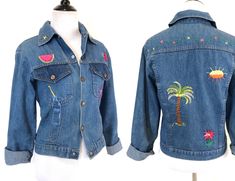 "Adorable 70s era denim jacket fits a women's size XS or S. Jacket snaps in front and also has snaps at the sleeve cuffs. It's a nice lightweight denim that fits a bit snug- perfect for petite ladies or juniors sizes. The original owner has embroidered charming little details all over the front & back! In terrific vintage condition with a little wear and a couple faint spots to the sleeve cuffs and elbow areas (see last photo), but nothing overwhelming or major... it just adds to the vintage Embroidered Casual Denim Jacket For Summer, Casual Embroidered Denim Jacket For Summer, Retro Fitted Denim Jacket For Summer, Vintage Cotton Denim Jacket For Summer, Retro Denim Jacket For Summer, Vintage Medium Wash Denim Jacket For Summer, Retro Blue Denim Jacket For Summer, Summer Retro Denim Jacket, Summer Embroidered Cotton Denim Jacket