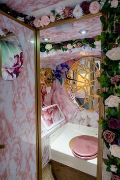 a pink and gold bathroom decorated with flowers