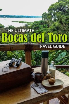 the ultimate bocas del toro travel guide on a wooden table in front of trees