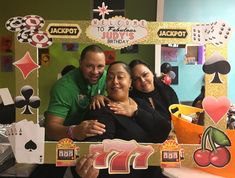 three people are posing for a photo in front of a carnival sign and other decorations