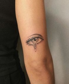 a woman's arm with a tattoo on it that has an eyeball in the middle