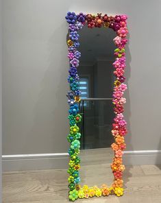 a large mirror made out of pom - poms in front of a gray wall