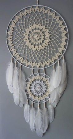 a crocheted dream catcher with white feathers