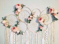 four dream catchers with flowers and leaves hanging on the wall